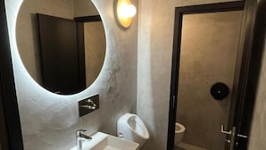 A modern bathroom with a large mirror, a white sink, and a toilet. - IZY STAY Hostel Bratislava (Bratislava)