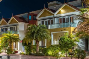 A hotel with multiple balconies, a reception area, and lush greenery. - Aranya Villa Sasan Gir (Talala)