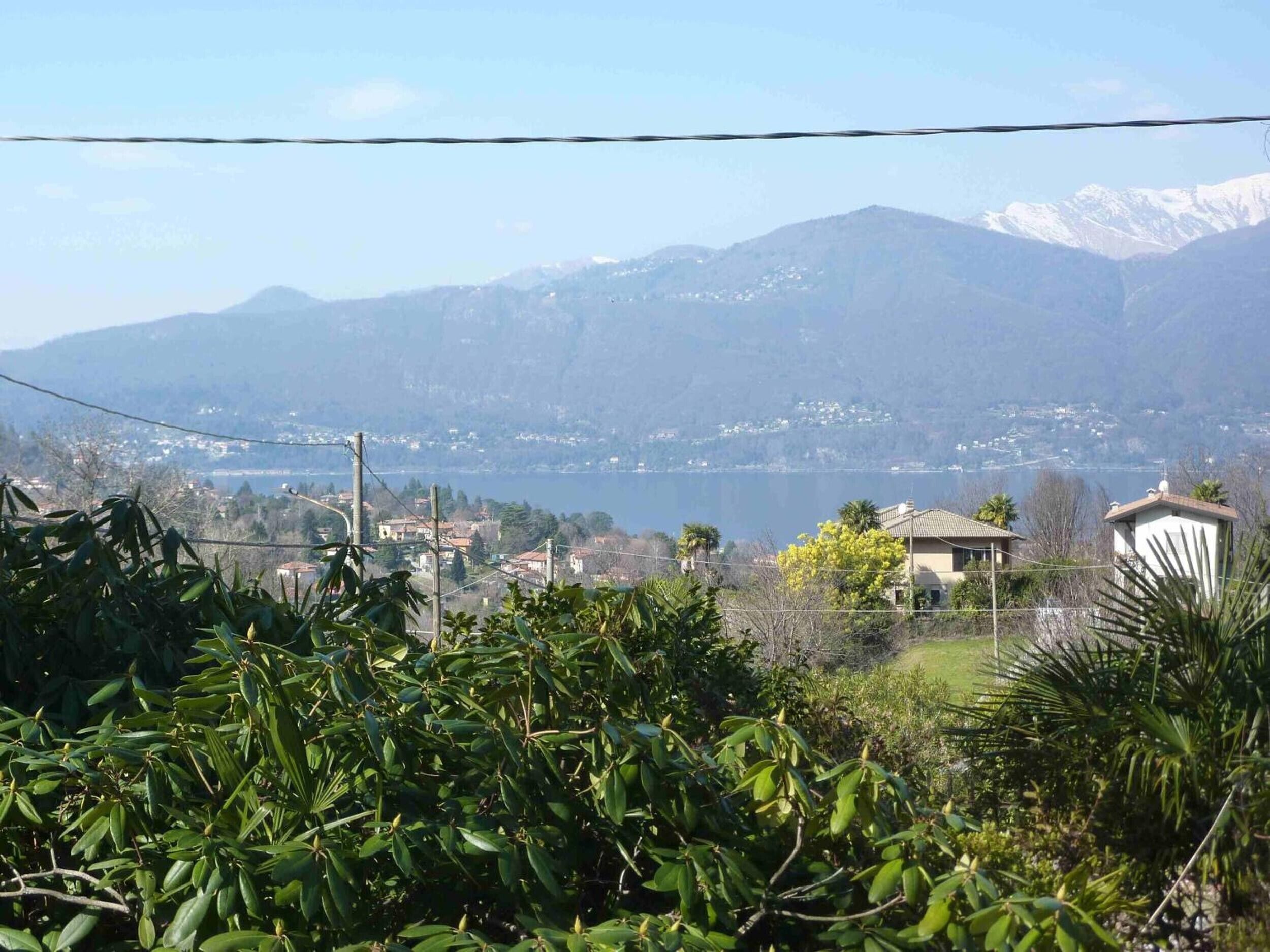 Un quartier résidentiel avec des maisons, un lac et des montagnes en arrière-plan.