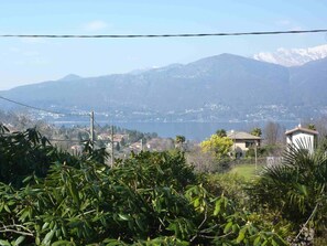 Ein Wohngebiet mit Häusern, einem See und Bergen im Hintergrund.