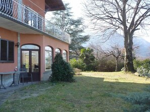 Un bâtiment doté d’un balcon, d’une porte et d’un petit jardin.