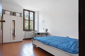 A bedroom with a bed, a desk, and a wardrobe. - Casa Corsini in Porto Valtravaglia – Lake View Apartment (Porto Valtravaglia)