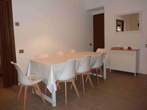 Un coin repas comprenant une table et des chaises, un buffet et un miroir au mur.