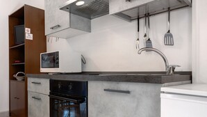 Eine moderne Küche mit Einbauofen, Mikrowelle und einem weißen Kühlschrank.