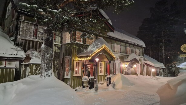 A traditional wooden building with snow-covered surroundings, featuring a well-lit entrance and a sign indicating a hotel. - Geilo Mountain Lodge (Geilo)