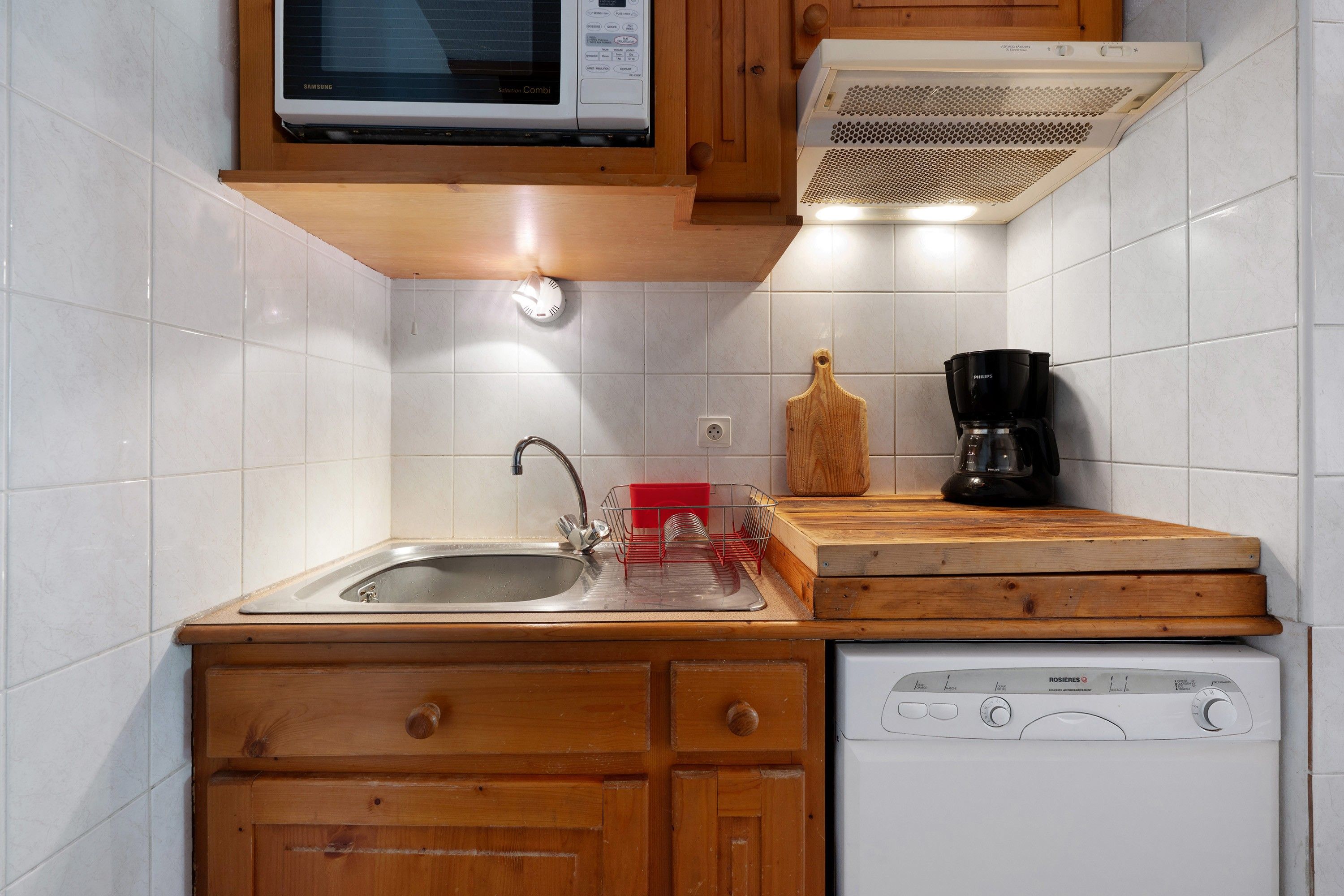 A kitchen with a microwave, a coffee maker, and a dishwasher.