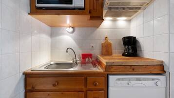 Una cucina accessoriata con microonde, macchina per il caffè e lavastoviglie.