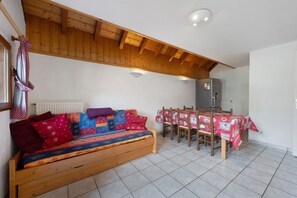 Una habitación acogedora con un banco de madera, una mesa de comedor con sillas y un radiador.