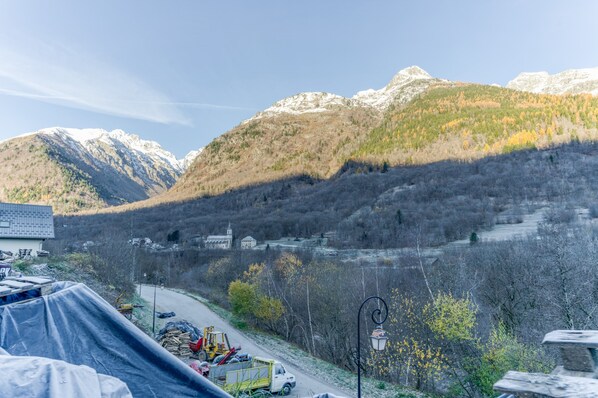 A mountainous landscape with a road, buildings, and a construction site. - Apartment 'Les Roches' with Mountain View (Saint-Colomban-des-Villards)