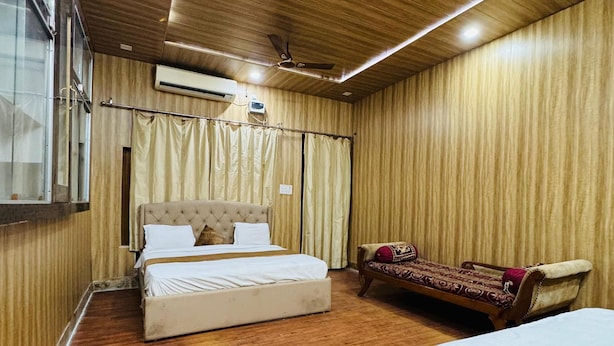 Una habitación con techo de madera, una cama, un sofá y un aire acondicionado.