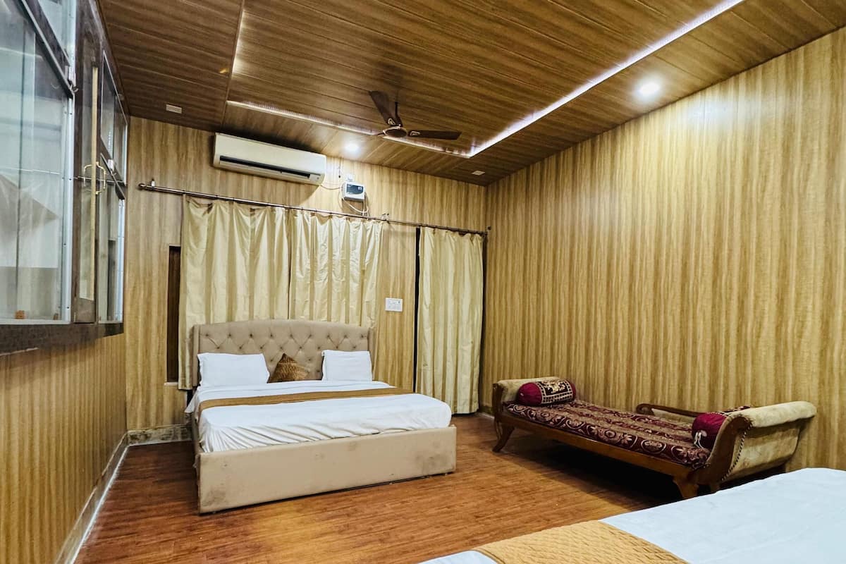 Una habitación con techo de madera, una cama, un sofá y un aire acondicionado.