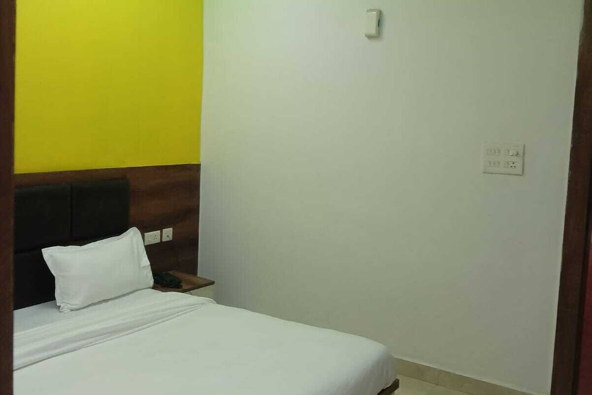 Quarto com cama, ventoinha no teto e mesa de cabeceira.