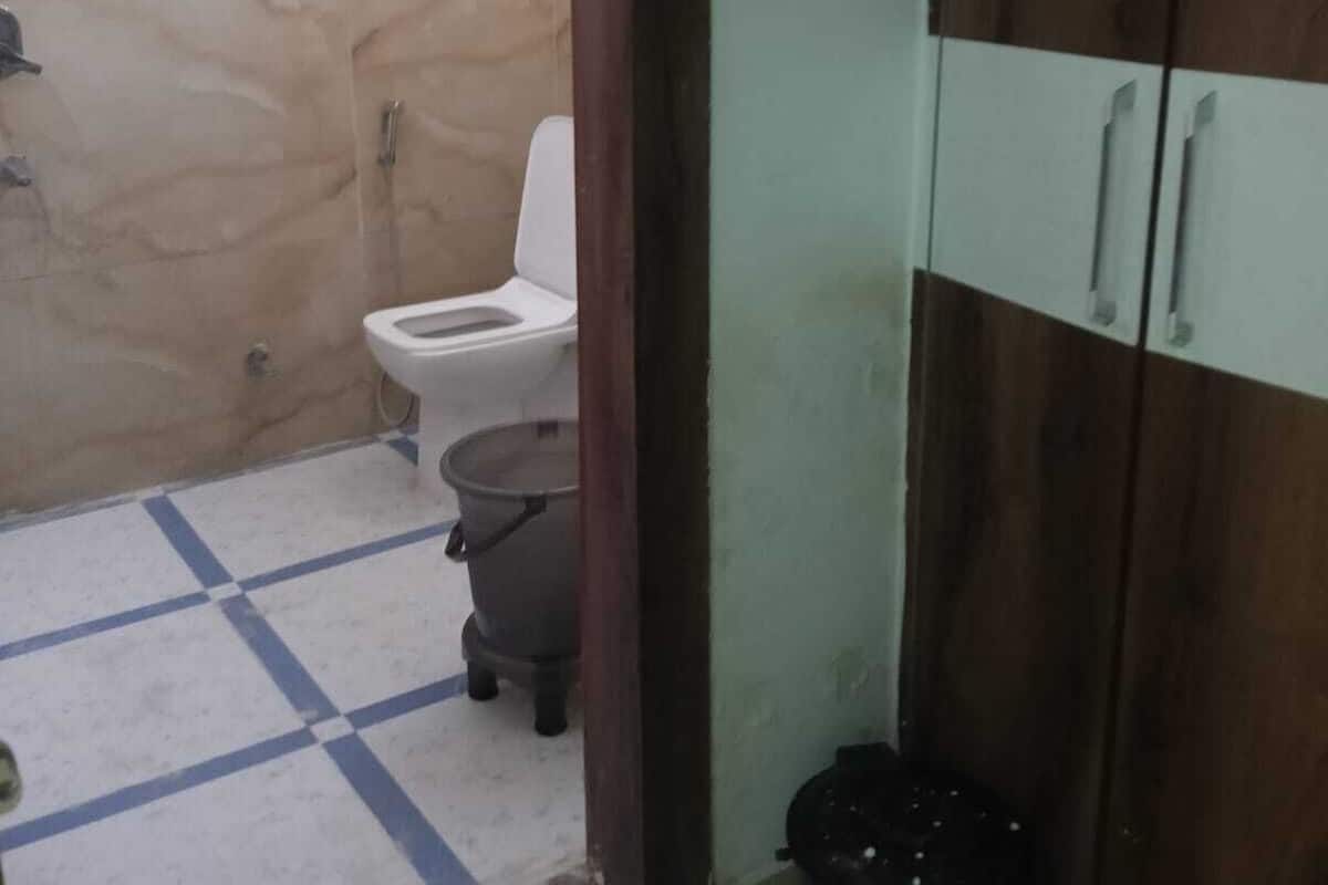 Um banheiro pequeno com vaso sanitário, chuveiro e armário.