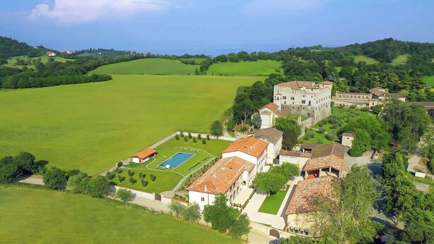 Una extensa propiedad con piscina, varias construcciones y amplios campos verdes.