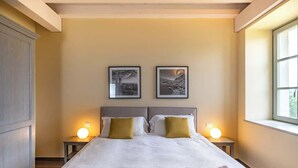 Habitaci ón de hotel con una cama grande, dos mesitas de noche con lámparas y dos cuadros en la pared.