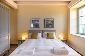 A hotel room with a large bed, two bedside tables with lamps, and two framed pictures on the wall. - Borgo di Drugolo Apartment n.12 (Drugolo)