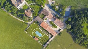 An aerial view of a residential area with a swimming pool, tennis court, and a small park. - Borgo di Drugolo Apartment n.9 (Drugolo)