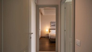 A hotel hallway leading to a bedroom with a bed, bedside table, and a lamp. - Borgo di Drugolo Apartment n.9 (Drugolo)