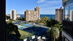 A view of a residential area with high-rise buildings, a sports field, and a clear blue sky. - Luxury Apartment with Sea View, Perfect for Couples and Mature Guests (Dehesa de Campoamor)