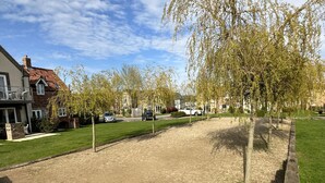 A residential area with houses, a dirt field, and trees. - The Saddlery  -  a cottage that sleeps 2 guests  in 1 bedroom (Bridlington)