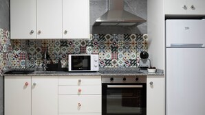 A kitchen with white cabinets, a microwave, a coffee maker, and a refrigerator. - Apartment in the center of Padrón 2 (Padrón)