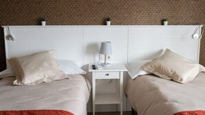 A twin room with two beds, a nightstand with a lamp, and a small table. - Apartment in the center of Padrón 2 (Padrón)