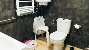 A modern bathroom with a toilet, a white sink, a shower area, and a towel rack. - Apartment in the center of Padrón 2 (Padrón)