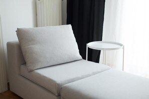 A minimalist room with a white sofa, a small round table, and a window with curtains. - Acropolitana Near Acropolis and Acropolis Museum (Athens)