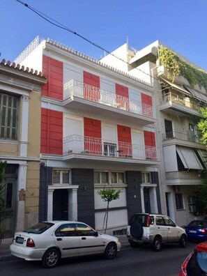 A multi-story building with balconies, a car parked in front, and a small tree in the front yard. - Acropolitana 2 Near Acropolis and Museum (Athens)