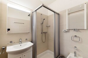 A modern bathroom with a glass-enclosed shower, a sink, and a towel rack. - Modern Comfort in Lugano (Mola Giglio) (Lugano)