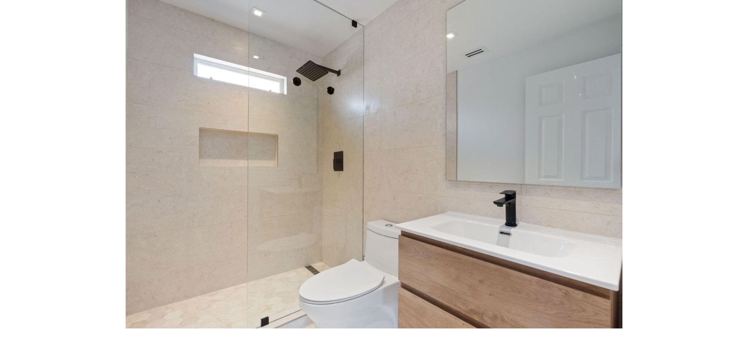 A modern bathroom with a shower, toilet, and sink.