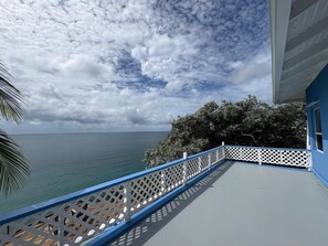 A balcony with a view of the sea and a white lattice railing. - Ocean-View Villa with Infinity Pool, St.Kitts (Frigate Bay)