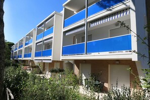 Ein modernes mehrstöckiges Gebäude mit Balkonen, einer Ziegel-Fassade und blauem Himmel.