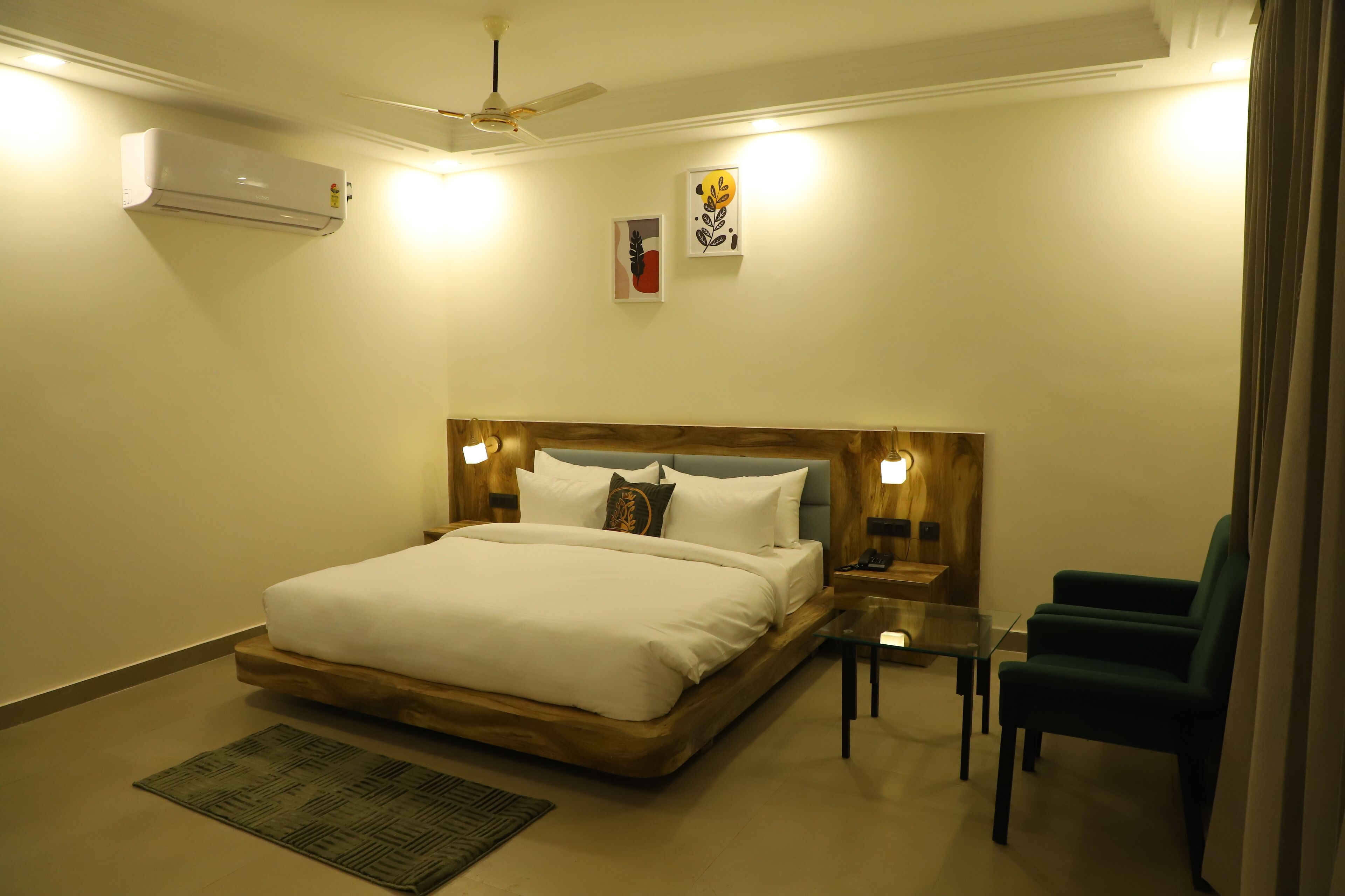 Ein Hotelzimmer mit einem Bett, Nachttischen, einem Sessel und einem Deckenventilator.