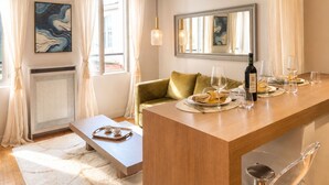 Un comedor moderno con una mesa de madera preparada para dos personas, un sofá y un radiador.