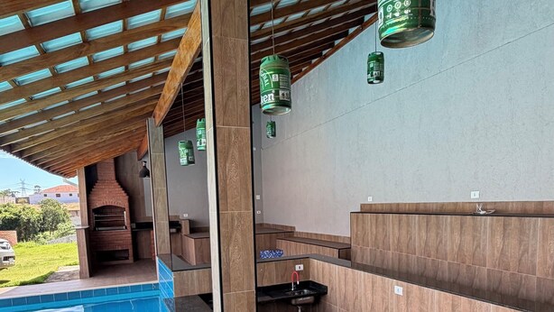 Ein Poolbereich mit gefliestem Boden, Holzboden und einem Kamin aus Ziegeln.