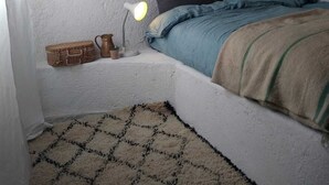 A small, cozy bedroom with a single bed, a bedside lamp, a small table with a lamp, and a woven basket. - Casa Marmoucha View Steppes de l'Atlas Yoga Retreat 11 pers (Aichoune)