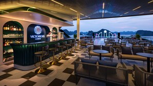 A bar area with a view of the water, checkered flooring, and bar stools. - Victorious Cruise (Tuan Chau)