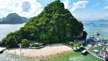 Una isla tropical con playa, barcos y un templo.