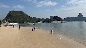 A beach with boats and people. - Victorious Cruise (Tuan Chau)