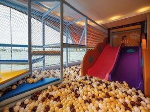 Un'area giochi per bambini con piscina di palline e scivoli.