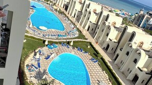 A resort with two large swimming pools, sun loungers, and a view of the ocean. - Luxury Apartment- Sahl Hasheesh- Gravity Hotel (Sahl Hasheeh)