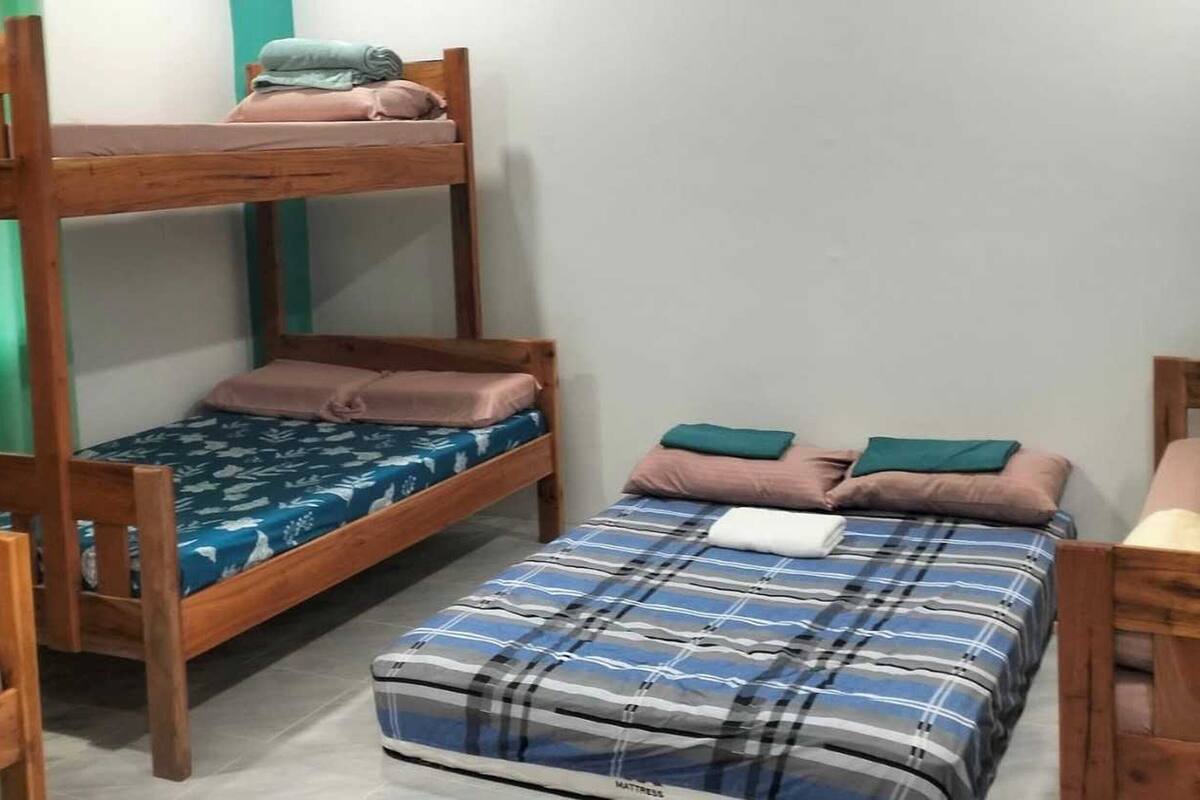 Quarto tipo dormitório com beliches e uma cama individual.