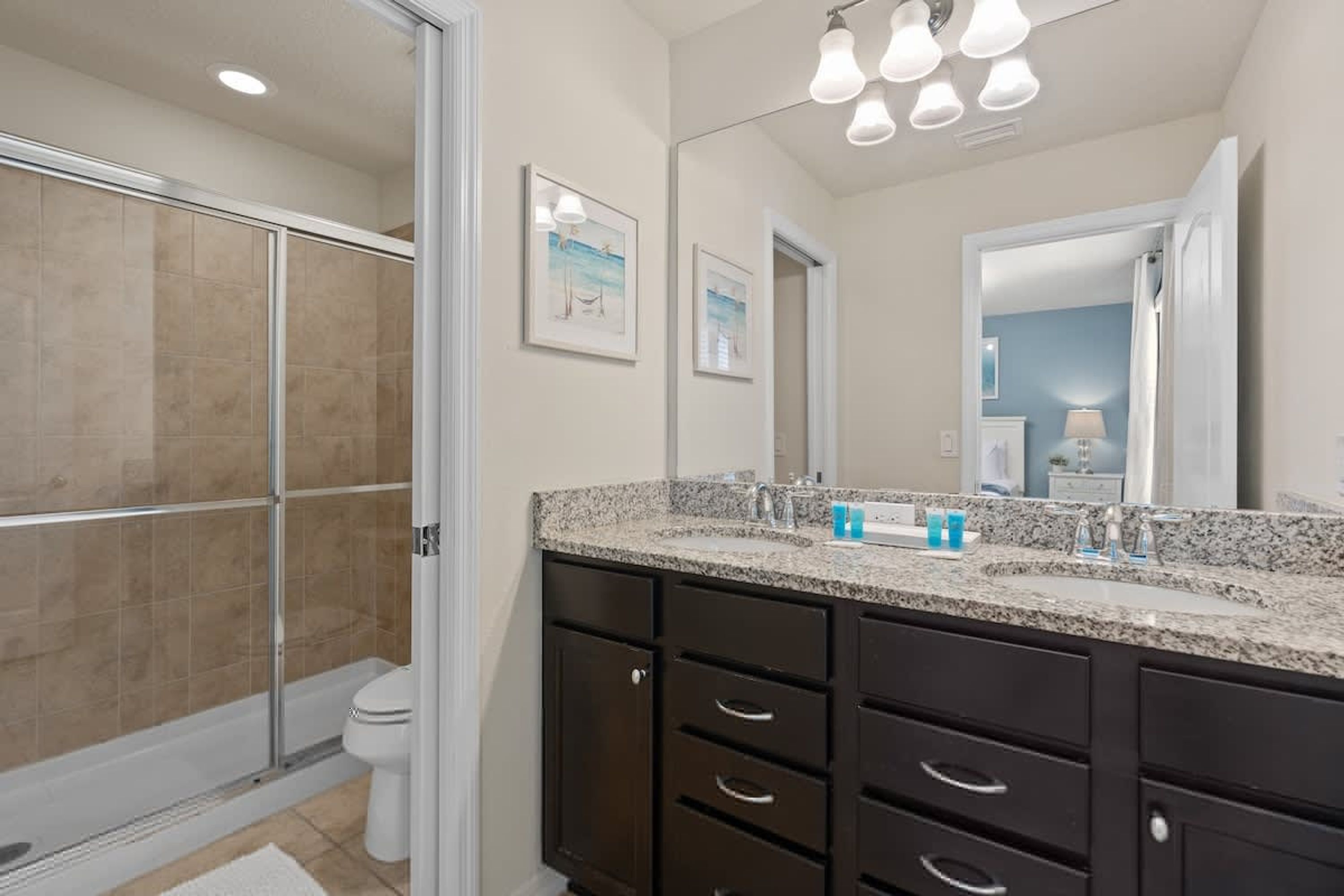 Une salle de bain équipée d’une douche, d’un lavabo, d’un miroir et de toilettes.