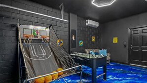 A room with a basketball hoop, a foosball table, and a pool table. - Ultimate 6BR Fun Pool Table Movie Games (Kissimmee)