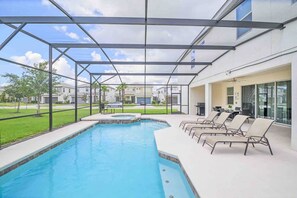 A swimming pool with lounge chairs and a covered patio area. - The Big Oasis 11br Luxury Stay (Kissimmee)