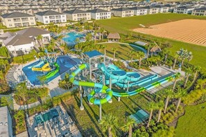 Eine Luftaufnahme eines Resorts mit mehreren Schwimmbecken, Wasserrutschen und einer großen Rasenfläche.