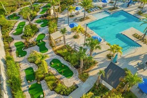Ein Golfplatz mit Schwimmbad und Liegebereichen.