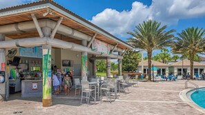 A covered outdoor bar area with a poolside seating arrangement and a pool. - Toy Story Villa - 5BD Game Room Pool Spa Near Disney (Davenport)