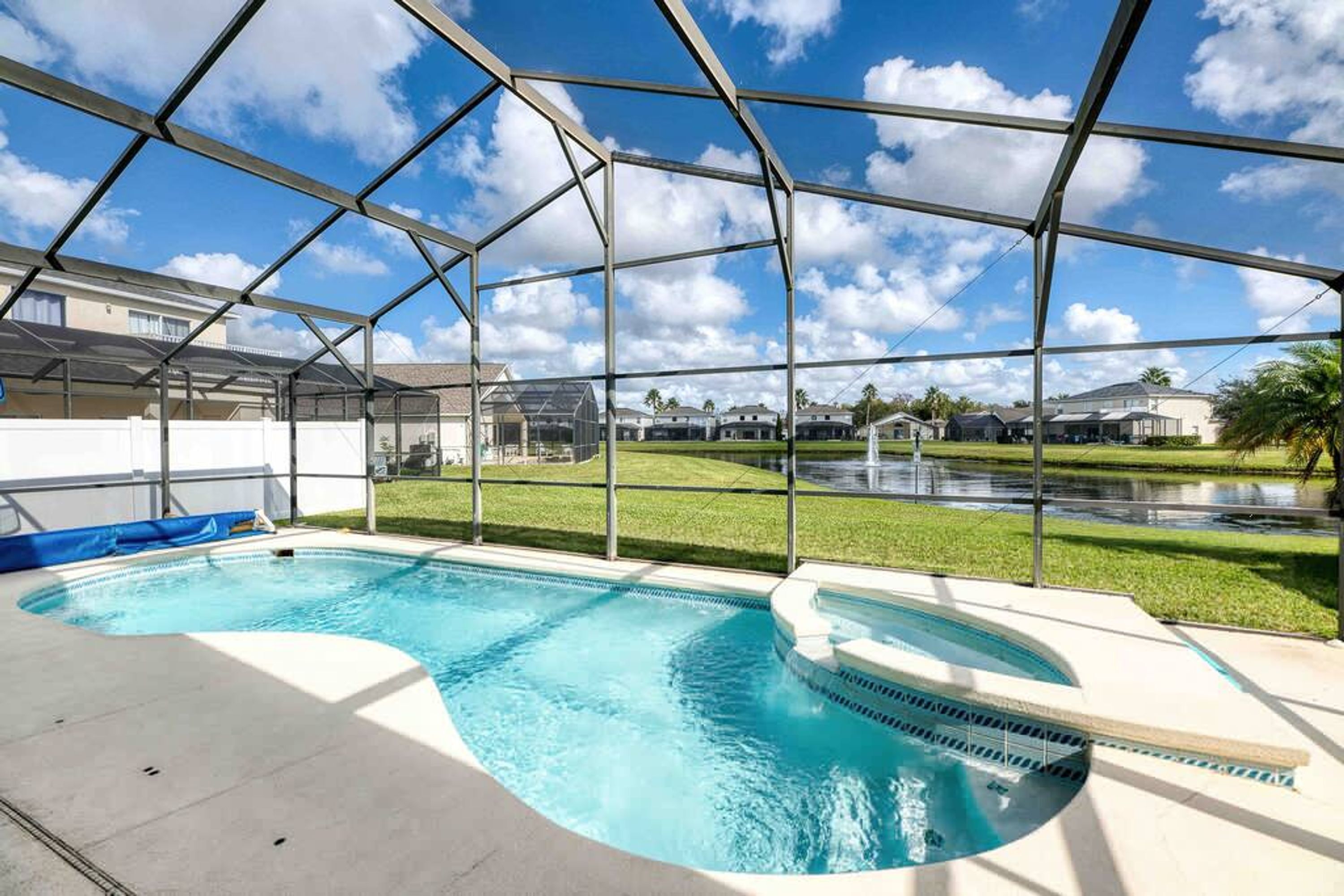A covered outdoor swimming pool with a clear view of the surrounding neighborhood.